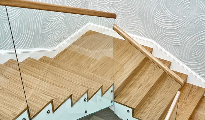 A wooden staircase with a glass railing, providing a modern and elegant touch to the overall design.
