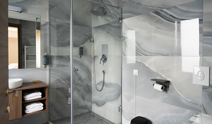 A modern bathroom with a transparent shower door and a toilet.