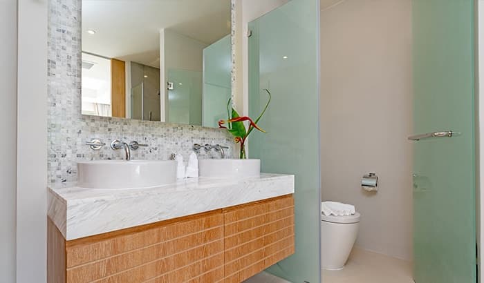 A modern bathroom with two sinks and a large mirror.